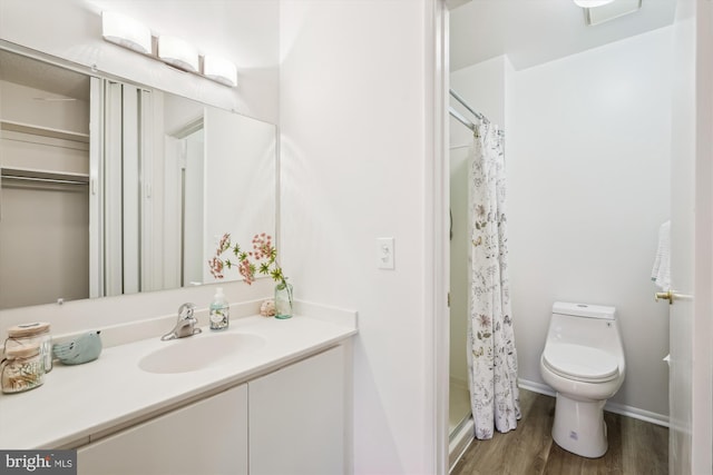 bathroom with visible vents, toilet, a shower with curtain, wood finished floors, and vanity