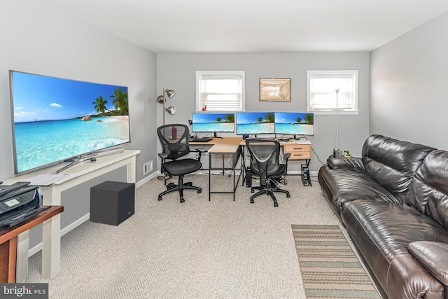 carpeted office space with baseboards, visible vents, and a healthy amount of sunlight