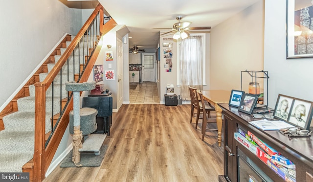 interior space with light wood-style flooring, baseboards, and ceiling fan