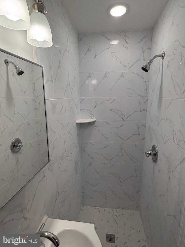 bathroom with sink and a tile shower