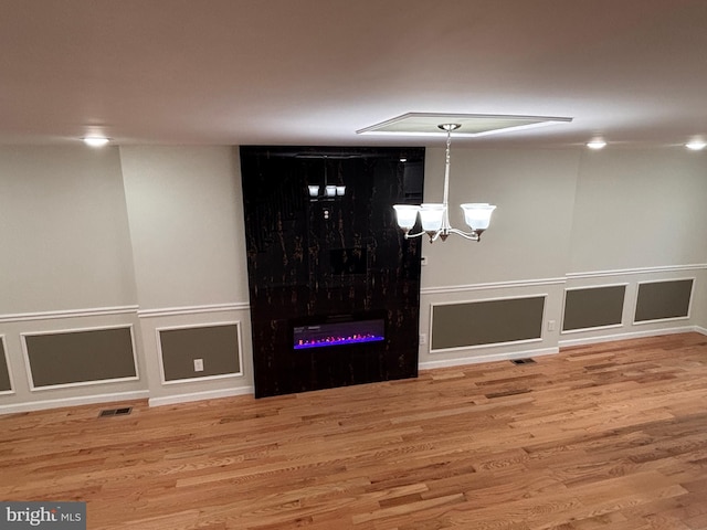 foyer entrance featuring wood-type flooring and a chandelier