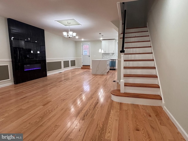 stairway with hardwood / wood-style flooring and an inviting chandelier