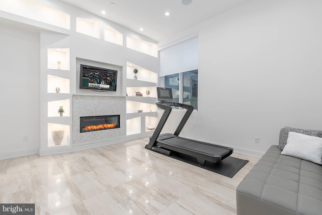 workout room with built in shelves and a towering ceiling