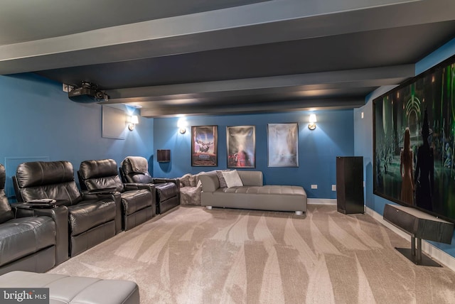 carpeted home theater room featuring beamed ceiling