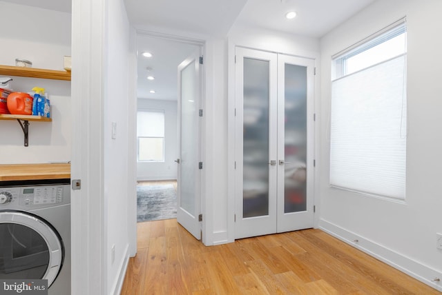 laundry area with washer / dryer, light wood-type flooring, and french doors