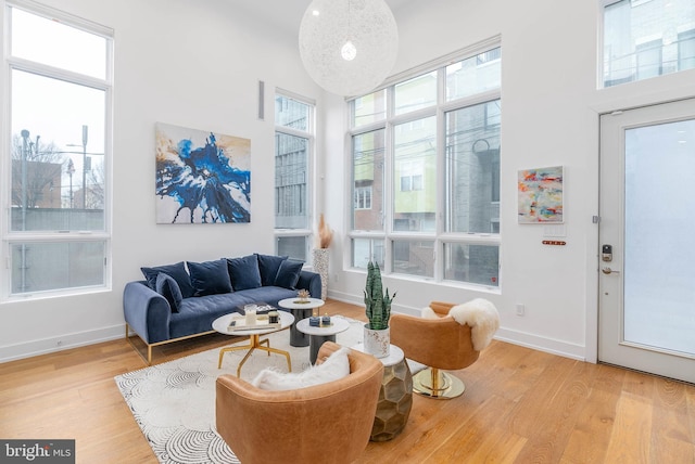 living room featuring a high ceiling and light wood-type flooring