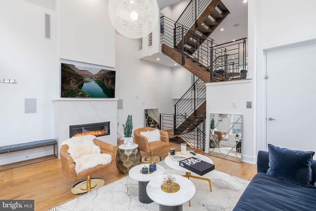 living room with hardwood / wood-style floors and a towering ceiling