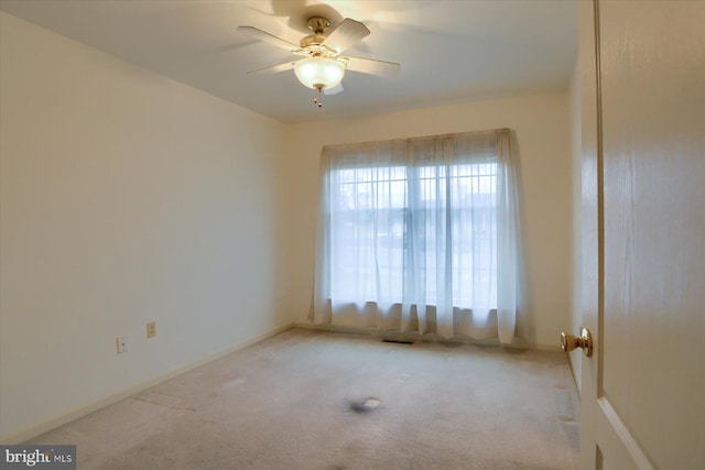 spare room featuring ceiling fan and light carpet