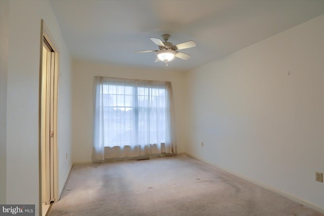 empty room featuring light colored carpet and ceiling fan