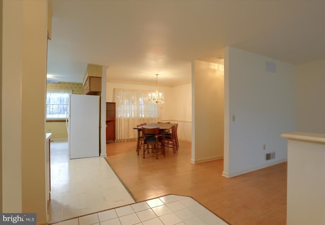 kitchen featuring a chandelier, white fridge, and light hardwood / wood-style flooring