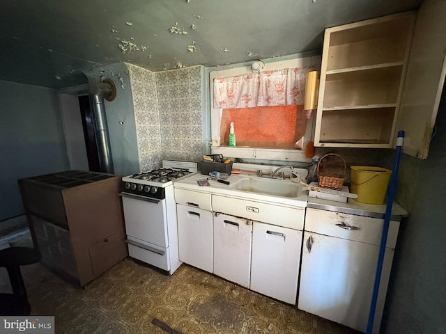 kitchen featuring white cabinetry, sink, and white range with gas stovetop