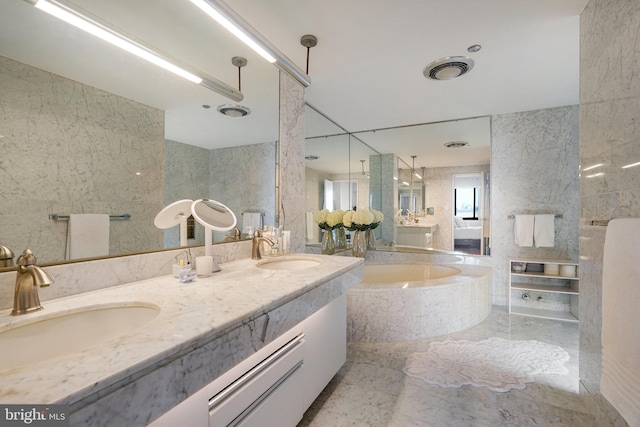 bathroom with vanity, tiled bath, and tile walls