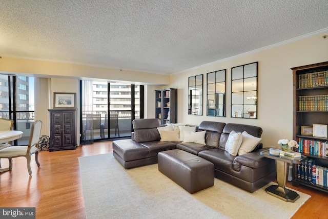 living room featuring wood-type flooring, ornamental molding, and a wealth of natural light