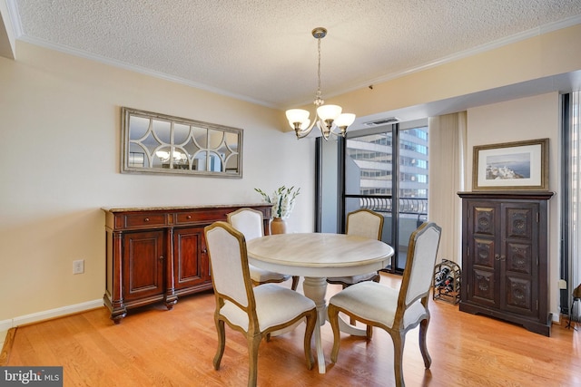 dining area with an inviting chandelier, crown molding, and light hardwood / wood-style flooring