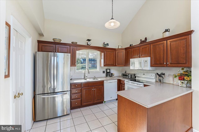 kitchen featuring sink, white appliances, light tile patterned floors, decorative light fixtures, and kitchen peninsula