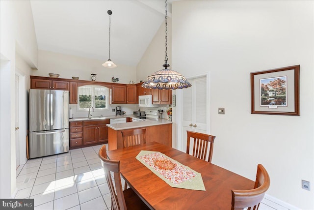 kitchen with decorative light fixtures, sink, light tile patterned floors, kitchen peninsula, and white appliances