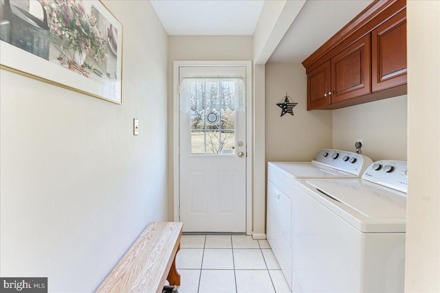 clothes washing area featuring independent washer and dryer, cabinets, and light tile patterned floors