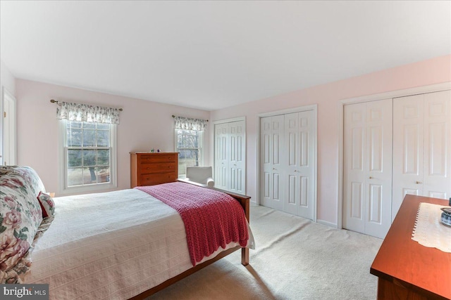 carpeted bedroom featuring two closets