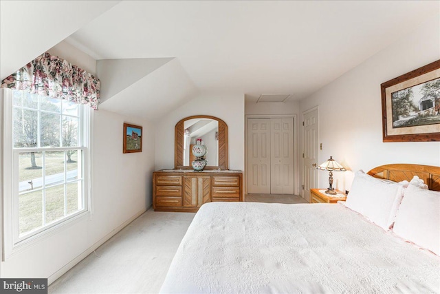 bedroom with a closet, vaulted ceiling, and carpet