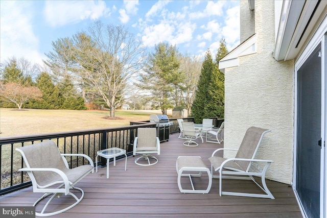 deck featuring area for grilling and a lawn