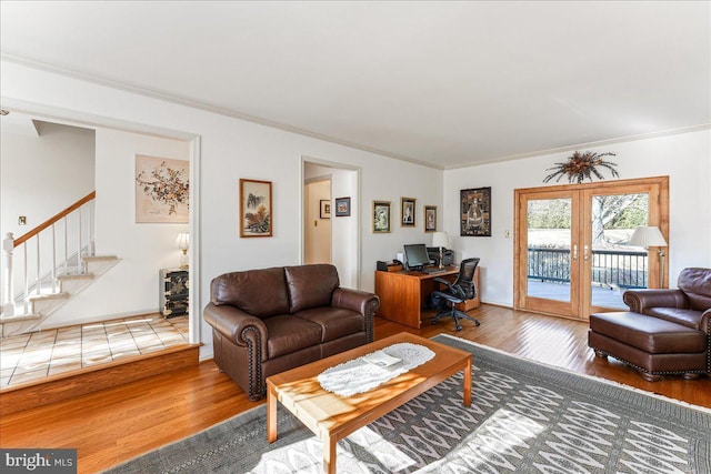 living room featuring wood-type flooring, ornamental molding, and french doors