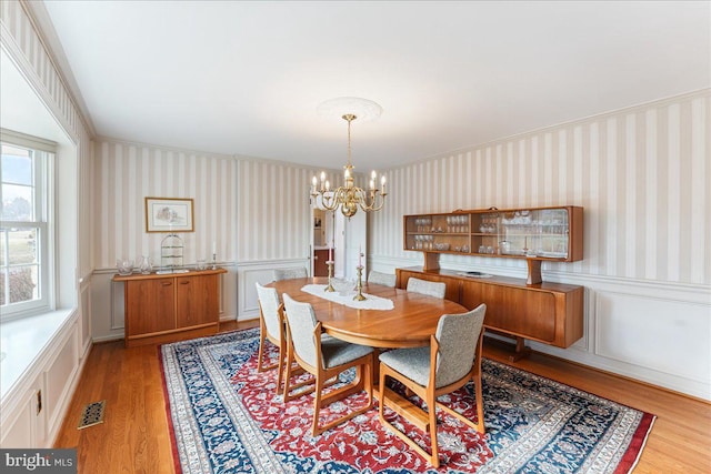 dining area with a chandelier and light hardwood / wood-style flooring