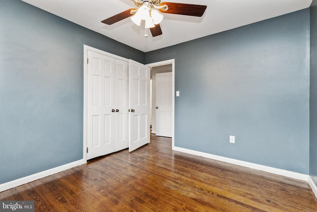 unfurnished bedroom with ceiling fan, dark hardwood / wood-style floors, and a closet