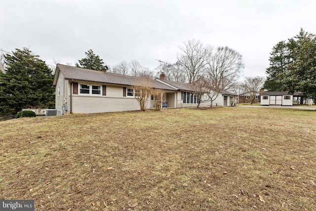 single story home with central AC unit, a front lawn, and a garage