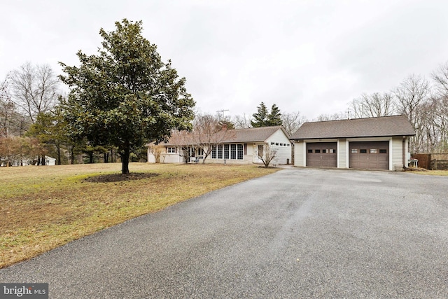 ranch-style home featuring a front lawn and a garage