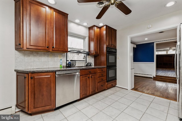 kitchen featuring sink, stainless steel dishwasher, light tile patterned floors, a baseboard radiator, and double oven