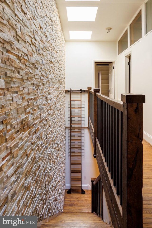 stairs featuring a skylight and wood-type flooring