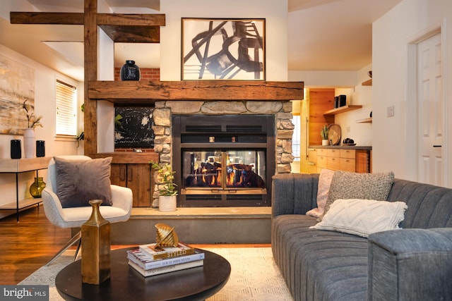 living room featuring wood-type flooring and a stone fireplace