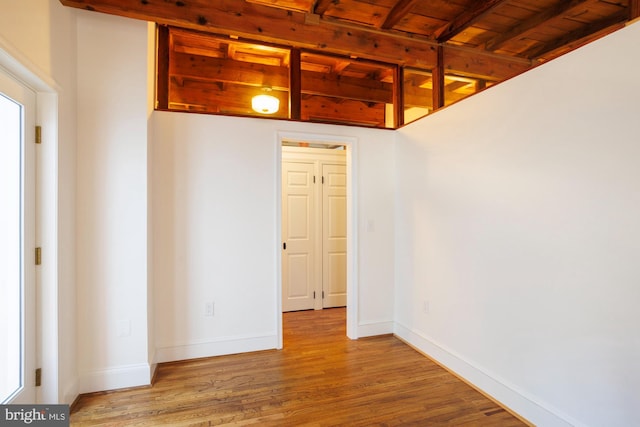 unfurnished room featuring wood ceiling, beam ceiling, and light hardwood / wood-style floors