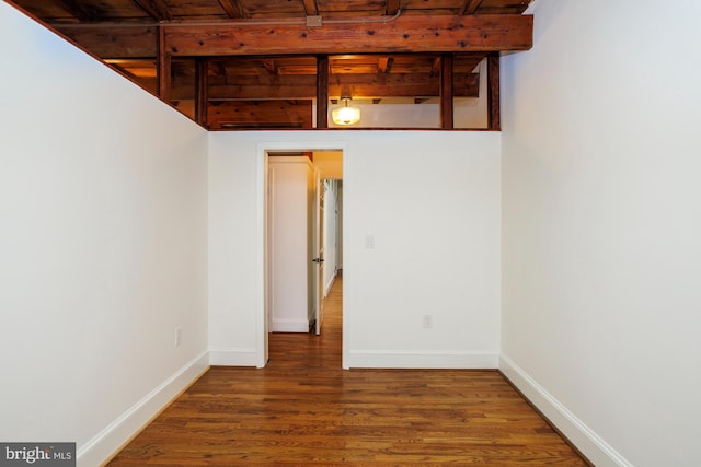 empty room featuring hardwood / wood-style floors, wood ceiling, and beamed ceiling