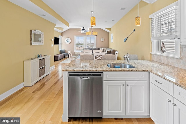 kitchen featuring sink, dishwasher, white cabinetry, hanging light fixtures, and light wood-type flooring