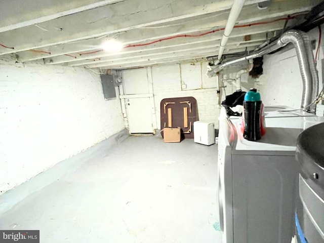 basement with electric panel and washer and clothes dryer