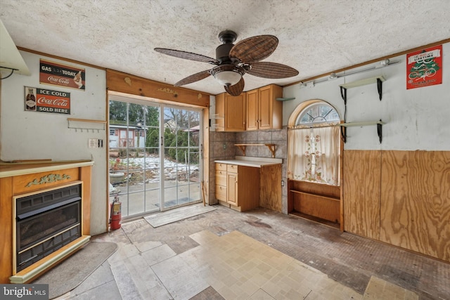 kitchen featuring heating unit, ceiling fan, and a textured ceiling