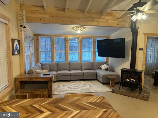 living area with a wood stove, ceiling fan, an AC wall unit, and beamed ceiling