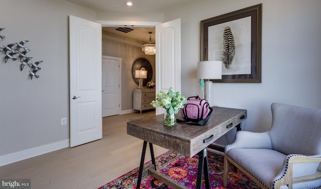 office space with wood-type flooring and an inviting chandelier