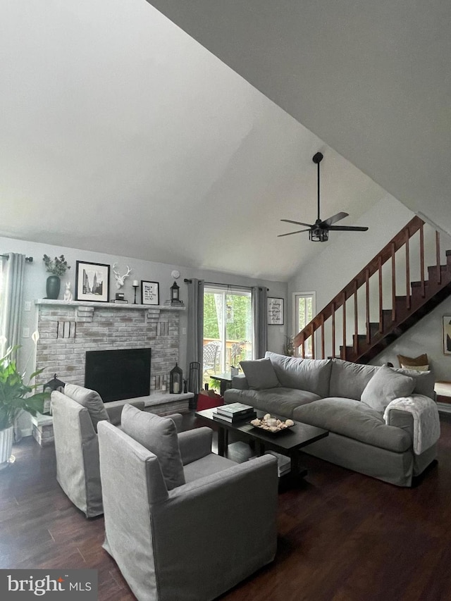 living room featuring dark hardwood / wood-style floors, ceiling fan, lofted ceiling, and a fireplace