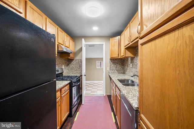 kitchen featuring light brown cabinetry, sink, light stone counters, tasteful backsplash, and appliances with stainless steel finishes