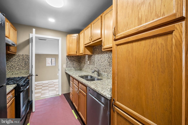 kitchen with stainless steel appliances, light stone countertops, sink, and backsplash