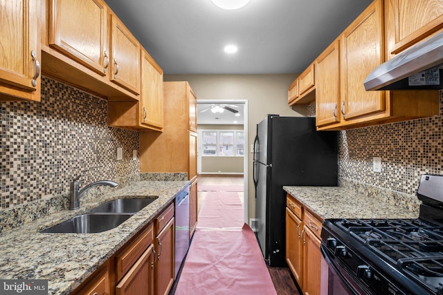 kitchen with sink, tasteful backsplash, ventilation hood, black appliances, and light stone countertops