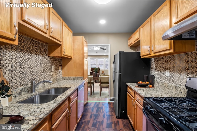 kitchen featuring sink, exhaust hood, black appliances, light stone countertops, and dark wood-type flooring