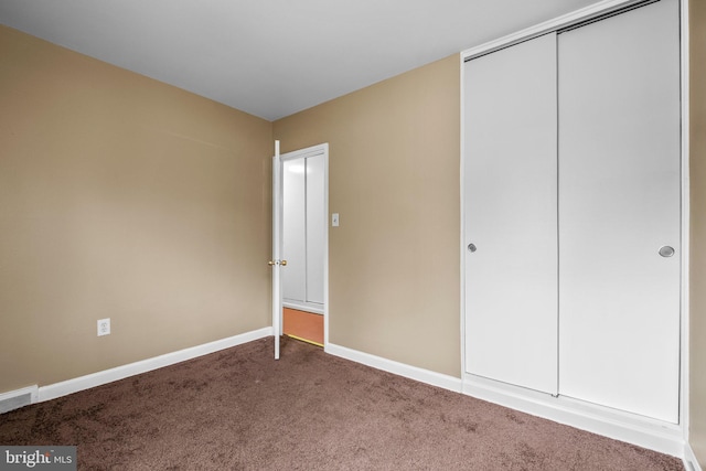 unfurnished bedroom featuring carpet flooring and a closet