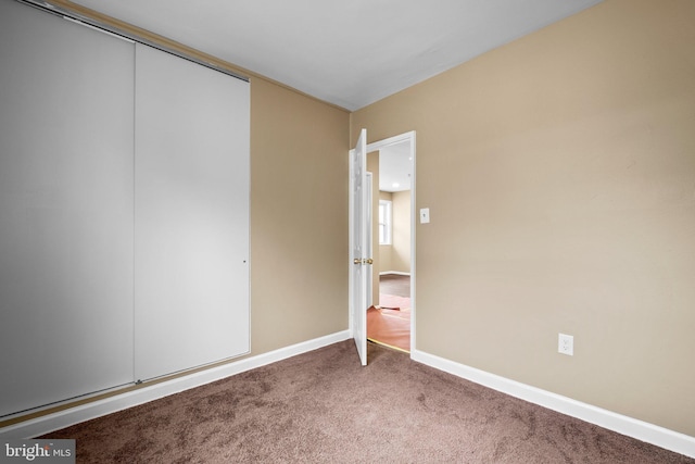 unfurnished bedroom with a closet and carpet flooring