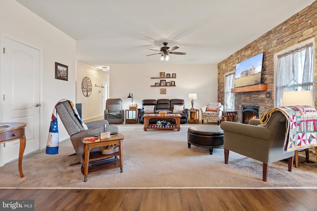 living room featuring a fireplace, light hardwood / wood-style floors, and ceiling fan