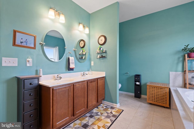 bathroom with tile patterned floors, vanity, toilet, and tiled tub