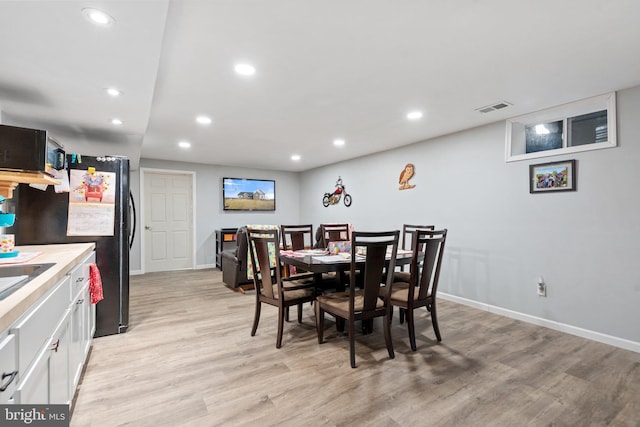 dining space with sink and light hardwood / wood-style floors