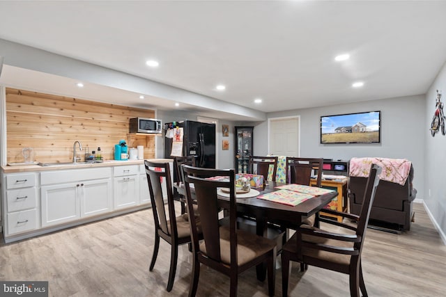 dining space featuring sink and light hardwood / wood-style flooring